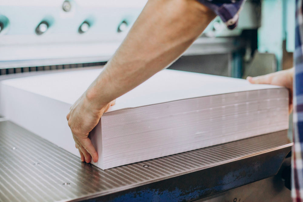 man working in printing house with paper and paints